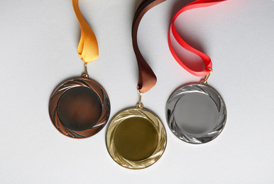 Gold, silver and bronze medals on white background, flat lay. Space for design