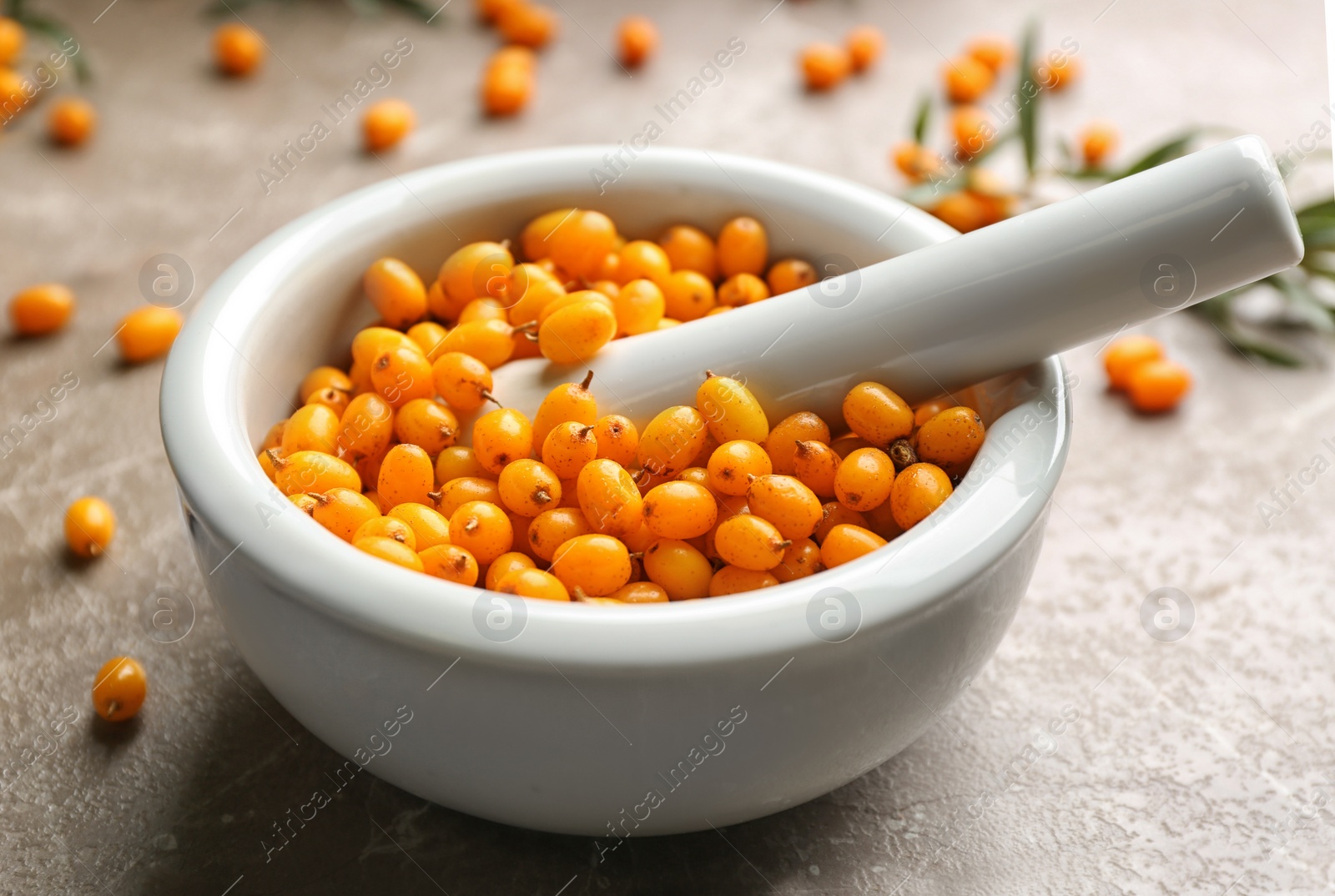Photo of Ripe sea buckthorn berries on marble table, closeup