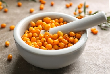 Photo of Ripe sea buckthorn berries on marble table, closeup