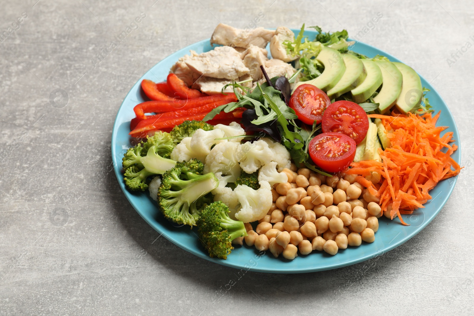 Photo of Balanced diet and healthy foods. Plate with different delicious products on grey table