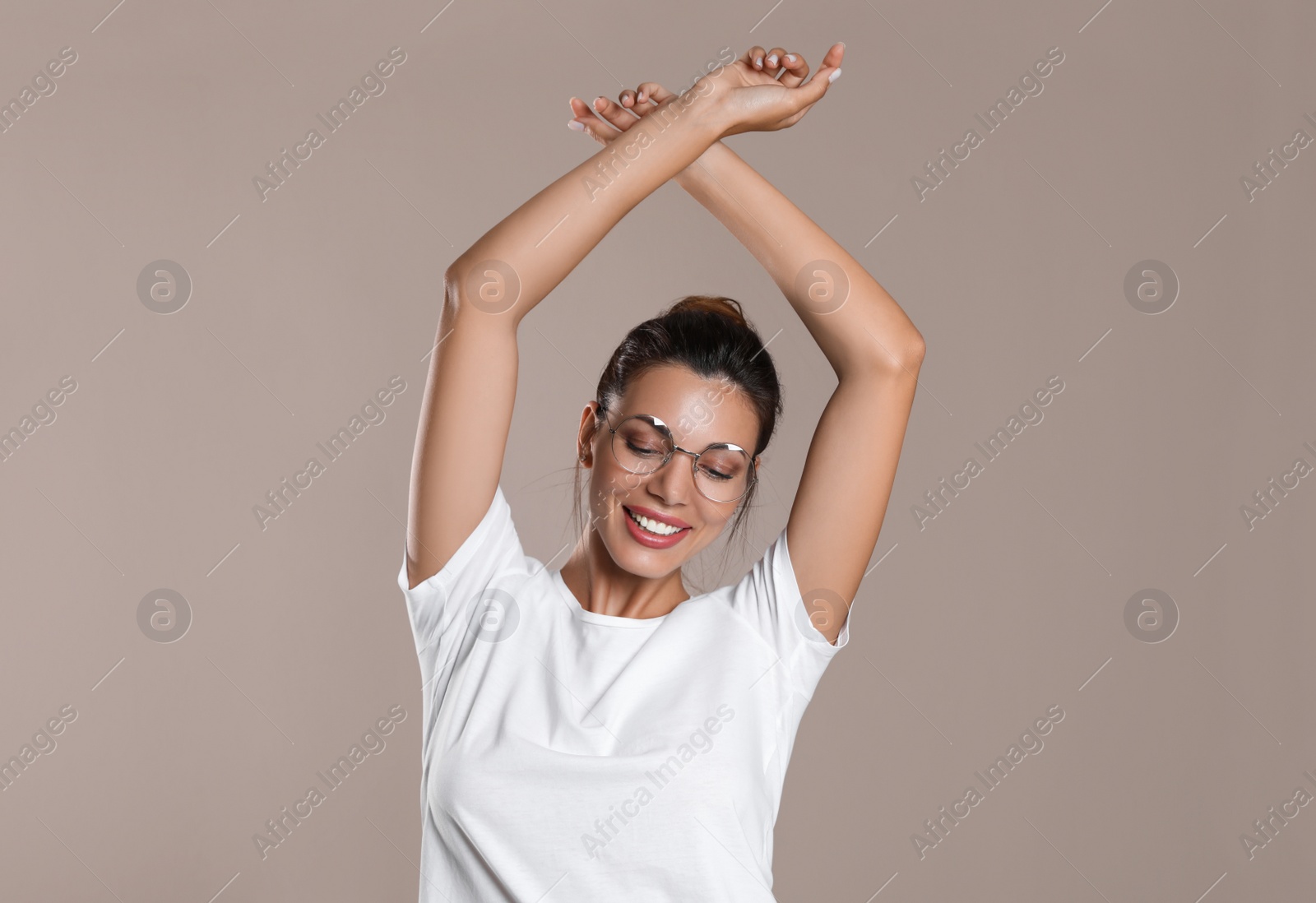 Photo of Beautiful woman in eyeglasses on light brown background