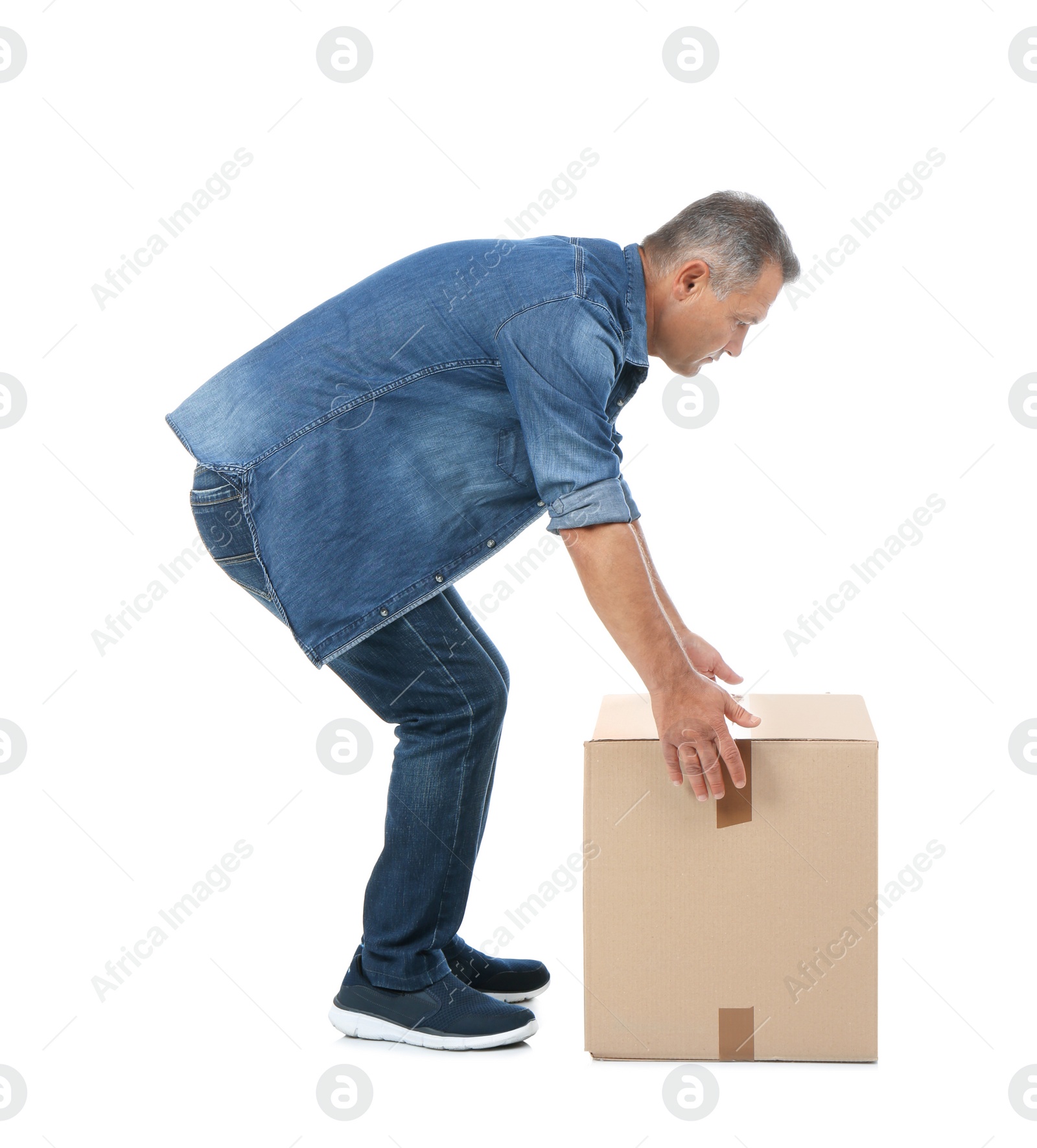 Photo of Full length portrait of mature man lifting carton box on white background. Posture concept