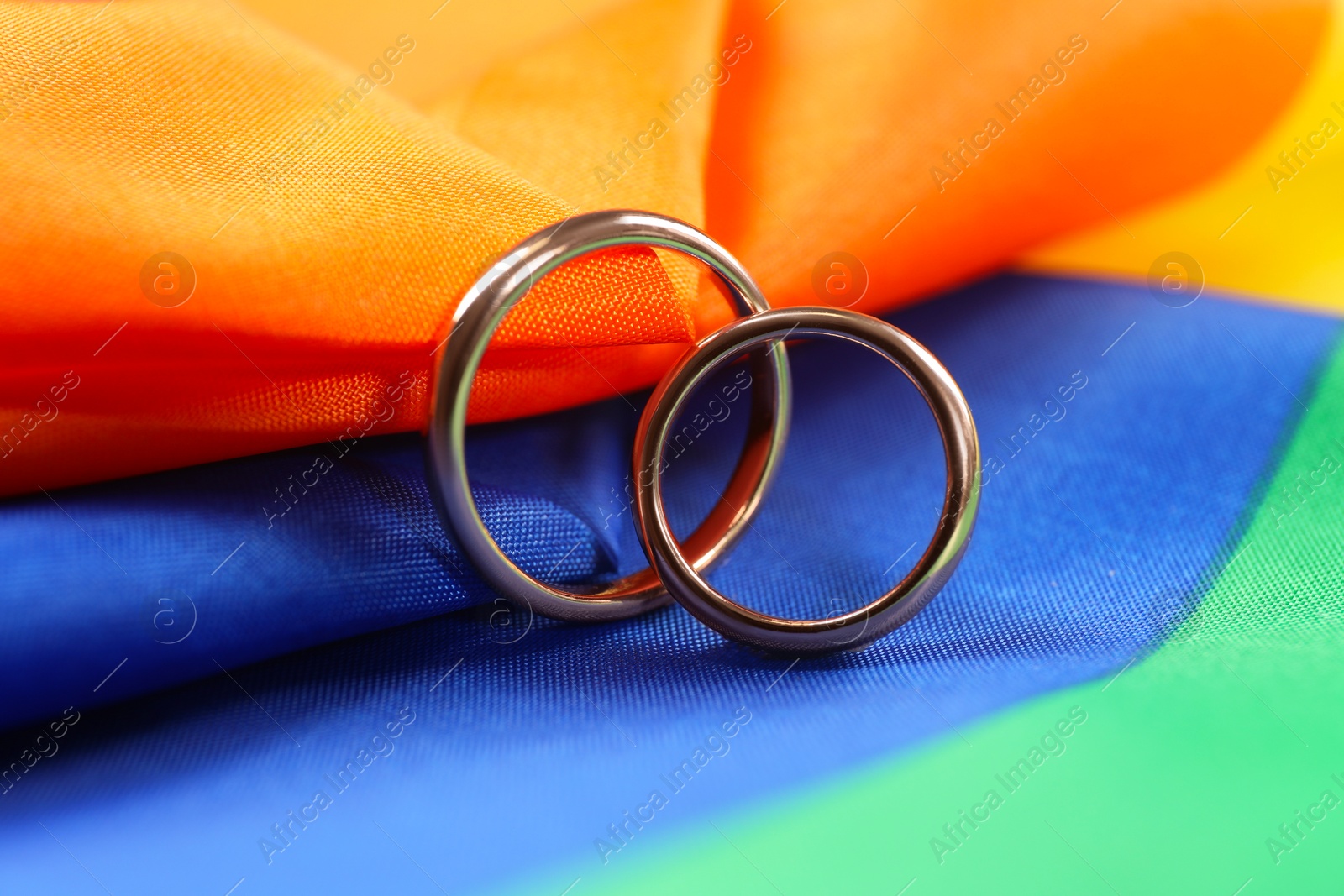 Photo of Wedding rings on rainbow LGBT flag, closeup