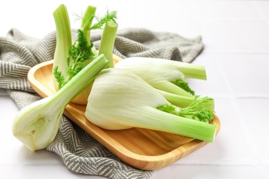 Photo of Whole and cut fennel bulbs on white table, closeup