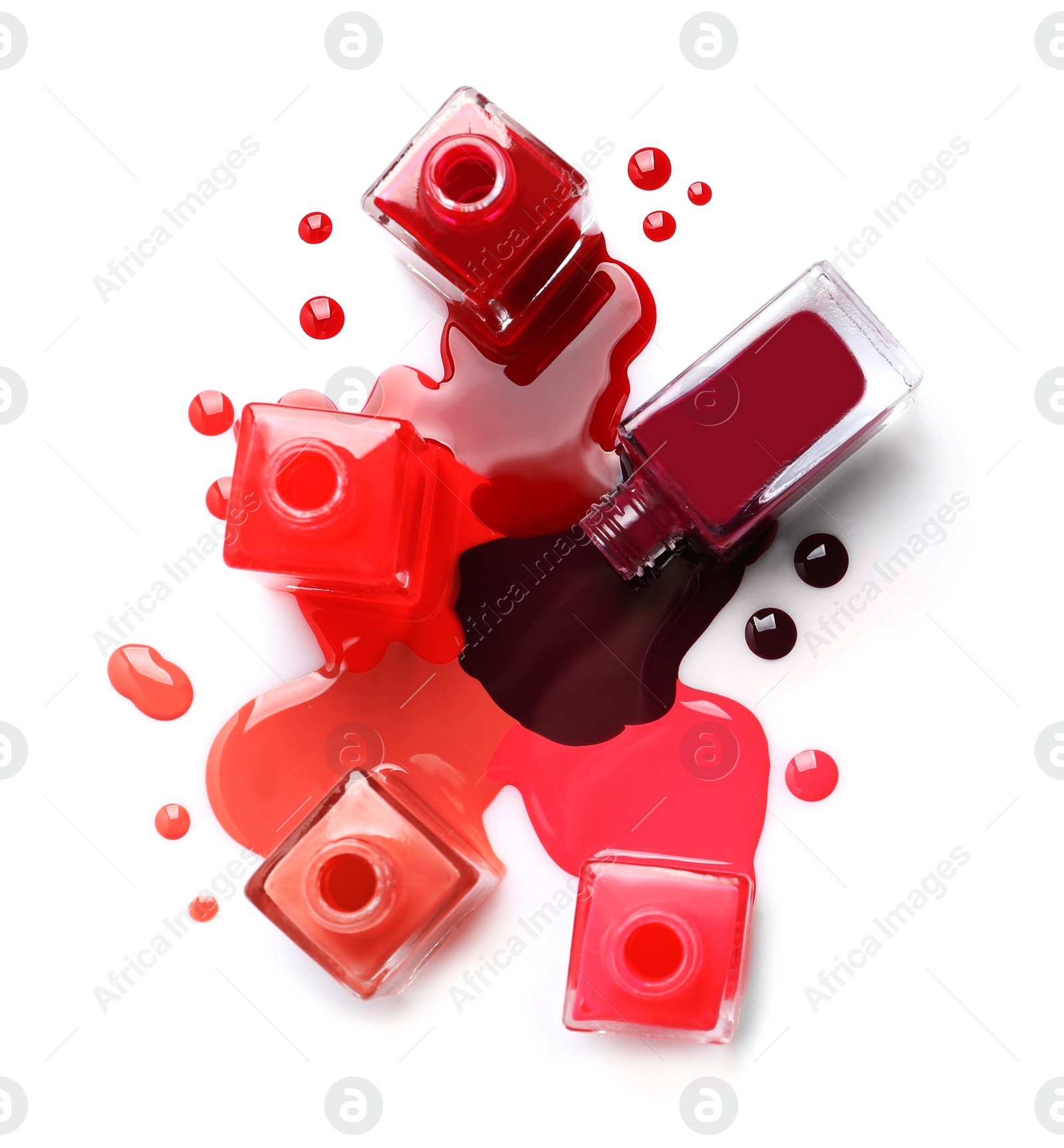 Photo of Spilled different nail polishes with bottles on white background, top view