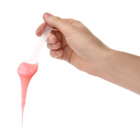 Photo of Woman holding spatula with hot depilatory wax on white background, closeup