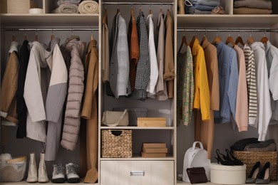 Photo of Wardrobe closet with different stylish clothes, accessories and home stuff