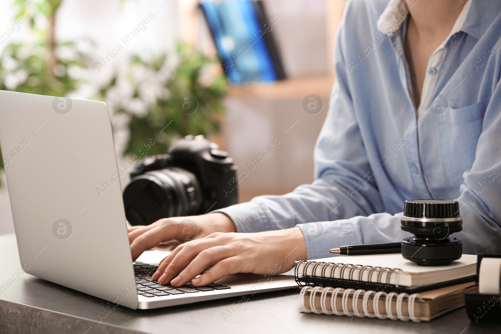 Photo of Journalist working with laptop at table, closeup