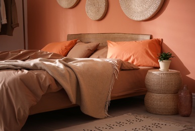 Photo of Bed with orange and brown linens in stylish room