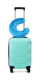 Photo of Soft travel pillow on turquoise suitcase isolated on white