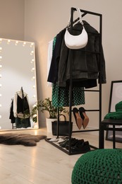 Modern dressing room interior with clothing rack and mirror