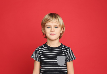 Portrait of cute little boy on red background