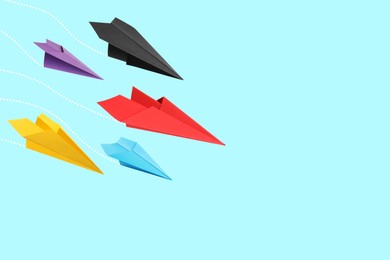 Image of Handmade paper planes on light blue background. Space for text
