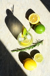 Tasty refreshing lemonade and ingredients on light grey table, flat lay. Summer drink