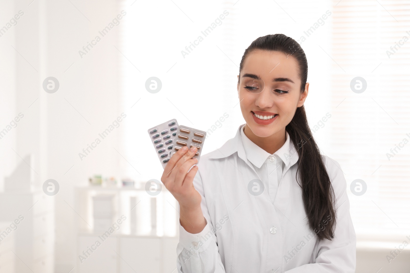 Photo of Portrait of professional pharmacist with pills in drugstore