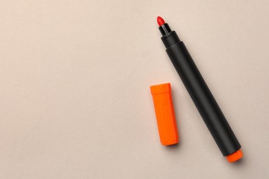 Photo of Bright orange marker on beige background, flat lay. Space for text