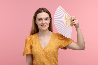 Photo of Happy woman with hand fan on pink background