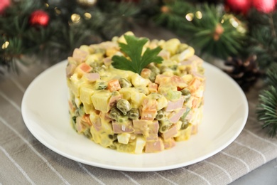 Photo of Traditional russian salad Olivier served on light table, closeup