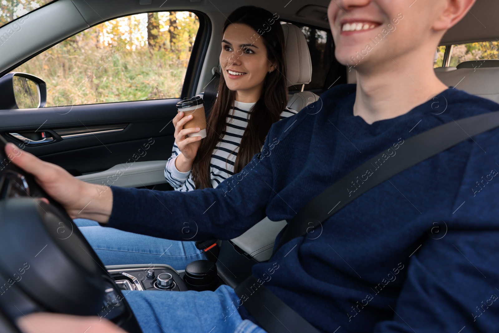 Photo of Happy young couple travelling together by car