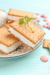 Photo of Sweet delicious ice cream cookie sandwiches on light blue wooden table