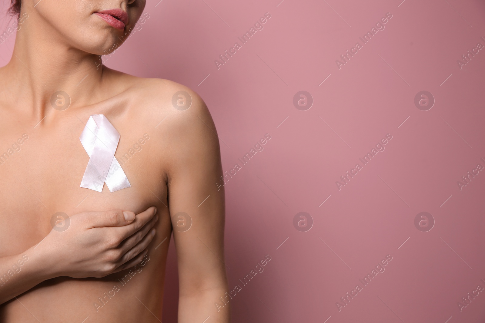 Photo of Naked woman with silk ribbon and space for text on color background, closeup. Breast cancer awareness concept