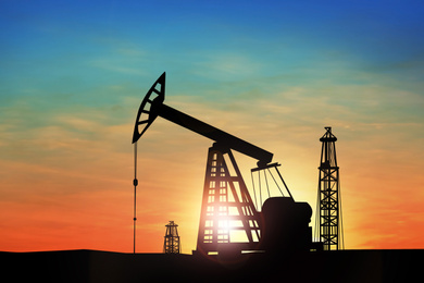 Image of Silhouette of crude oil pump at sunset