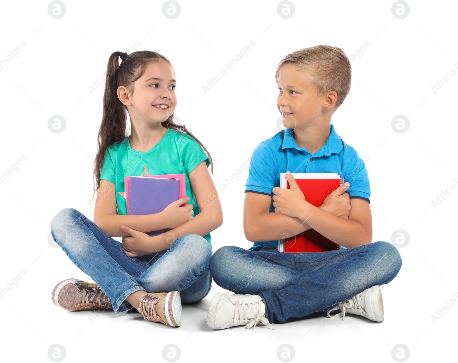 Photo of Little children with school supplies on white background