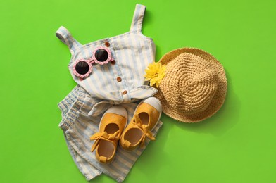 Photo of Stylish child clothes, shoes and accessories on green background, flat lay