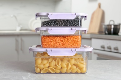 Stacked boxes with different food on table in kitchen