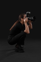 Photo of Professional photographer taking picture on black background