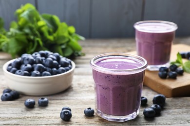 Photo of Freshly made blueberry smoothie on wooden table, space for text