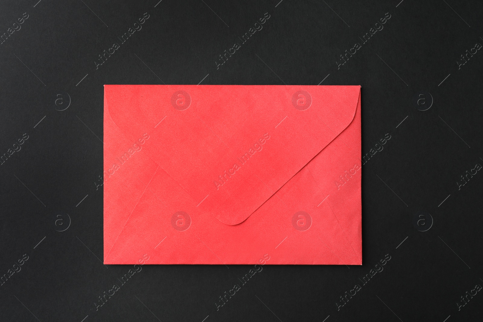 Photo of Red paper envelope on black background, top view