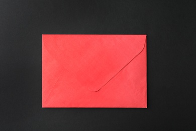 Red paper envelope on black background, top view