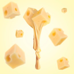 Pieces of cheese falling on yellow background