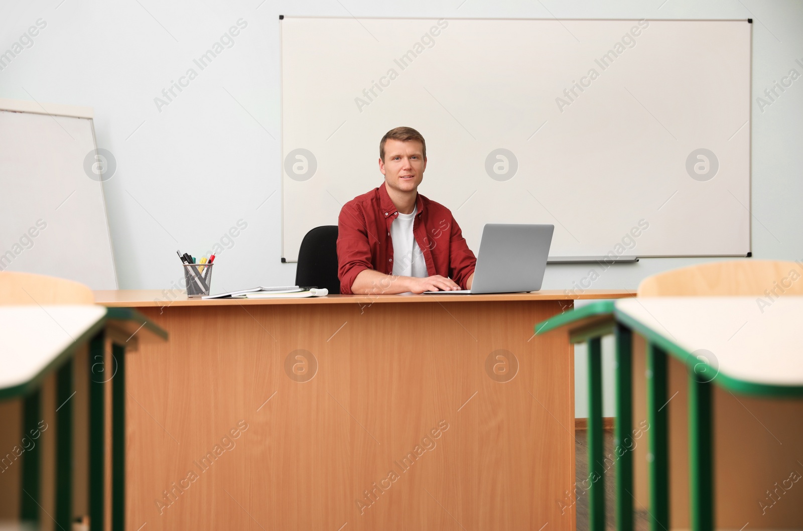 Photo of Male teacher at his desk in classroom