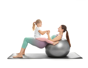 Young woman and her daughter doing exercise isolated on white. Home fitness