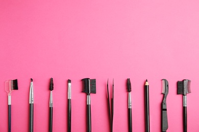 Photo of Set of professional eyebrow tools on pink background, flat lay. Space for text