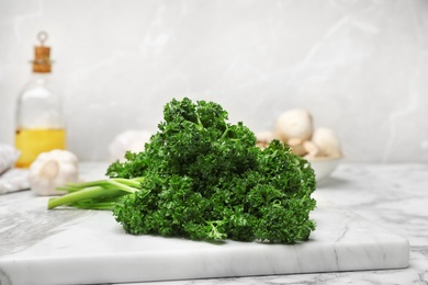 Photo of Board with fresh green parsley on table