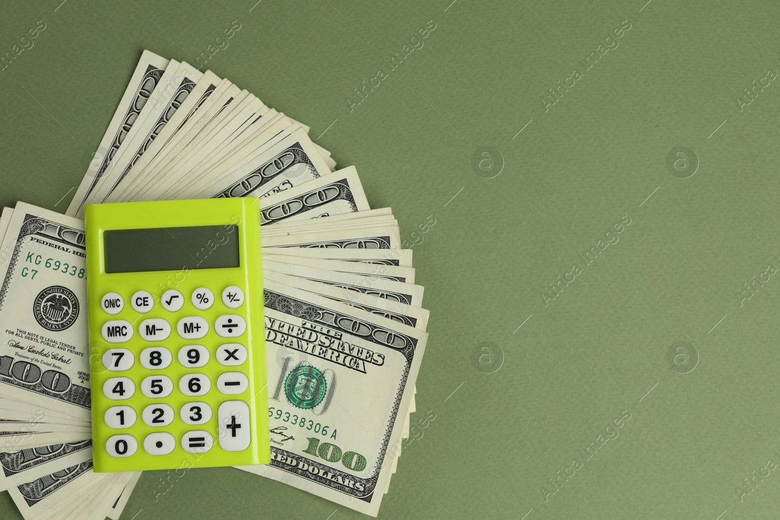 Photo of Money exchange. Dollar banknotes and calculator on green background, top view. Space for text