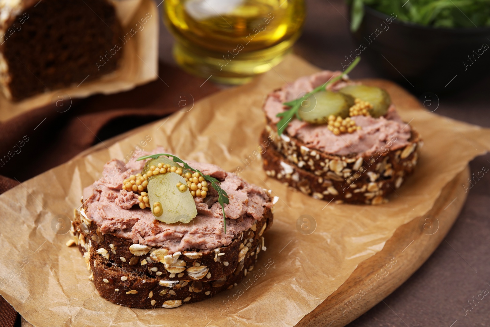 Photo of Delicious liverwurst sandwiches with pickled cucumber and mustard on grey table, closeup