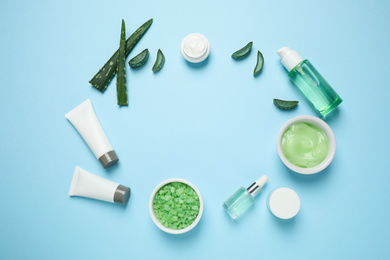 Photo of Flat lay composition with different cosmetic products and aloe on light blue background, space for text