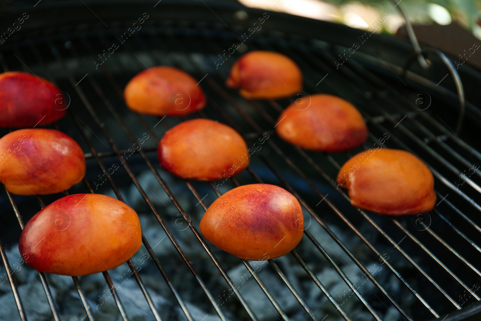 Photo of Modern grill with tasty juicy peaches outdoors, closeup