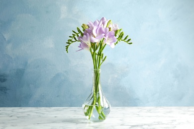 Bouquet of fresh freesia flowers in vase on table