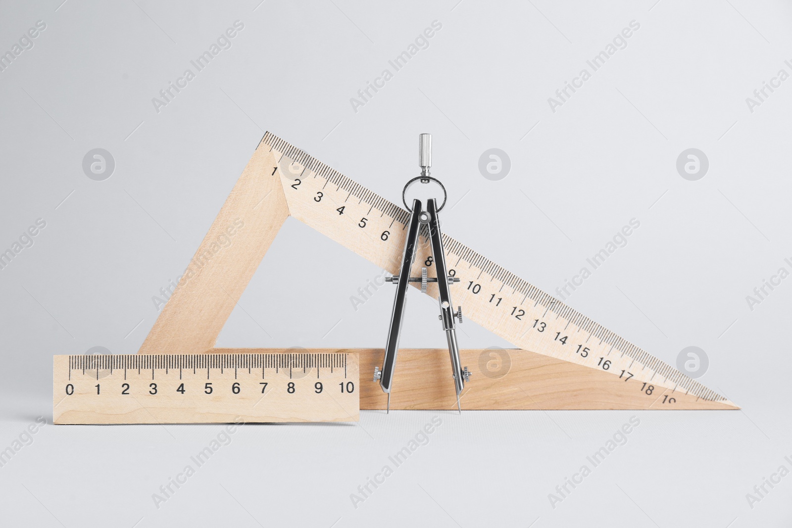 Photo of Ruler with measuring length markings, triangle and compass on white background