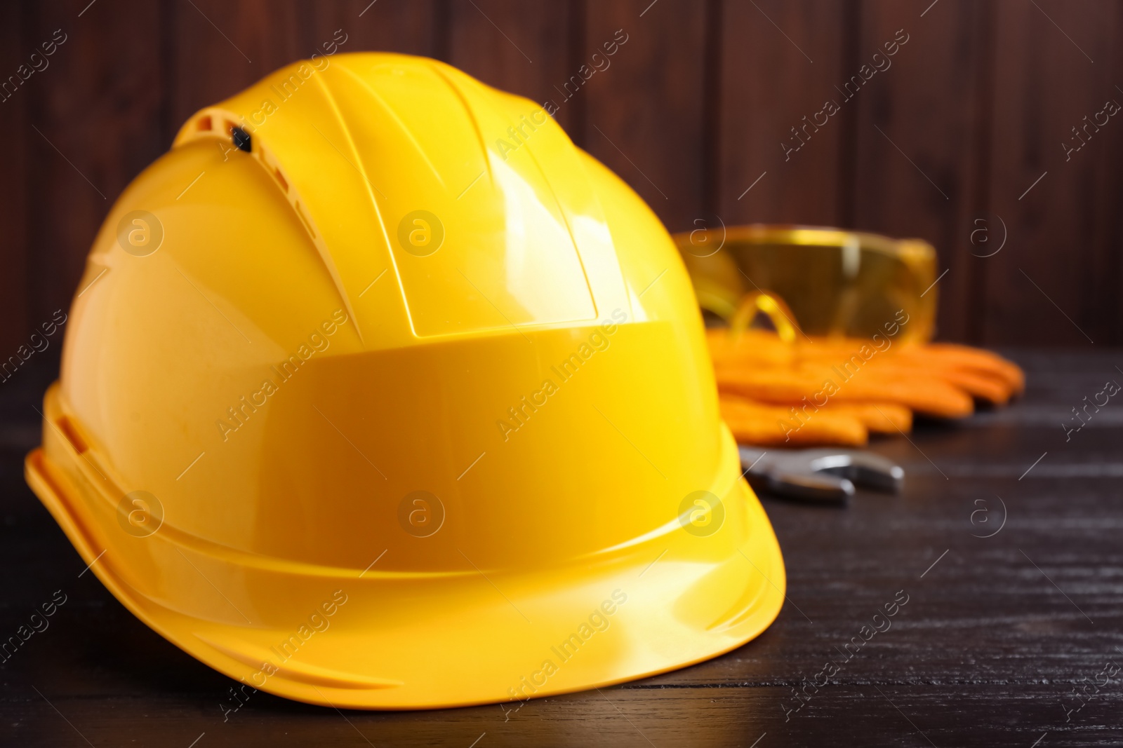 Photo of Hard hat and blurred safety equipment on background. Space for text