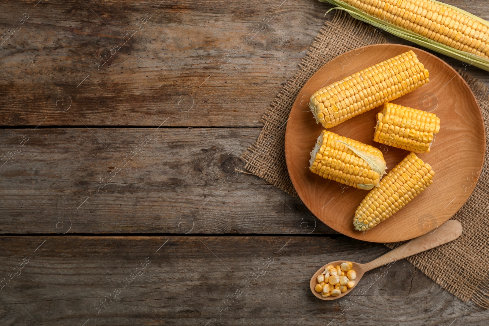 Photo of Flat lay composition with tasty sweet corn cobs on wooden background