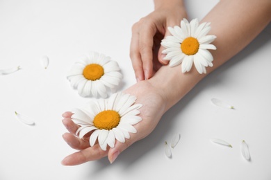 Photo of Woman with beautiful chamomile flowers on white background