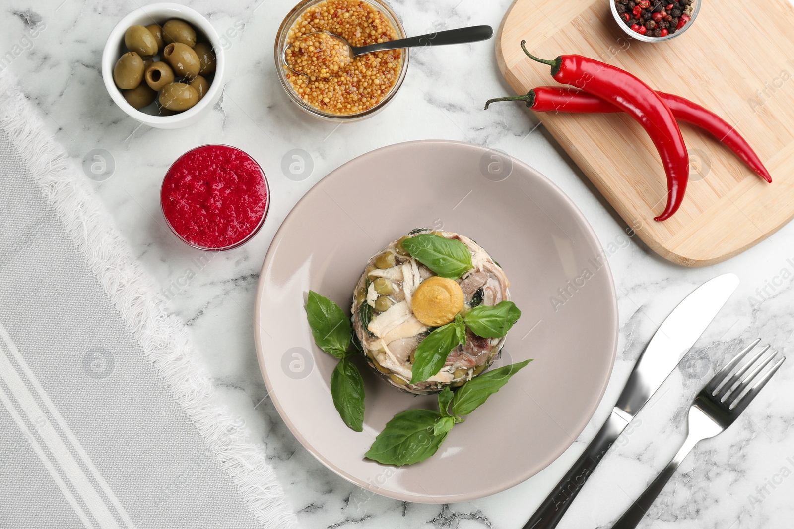 Photo of Delicious aspic with meat and vegetables served on white marble table, flat lay