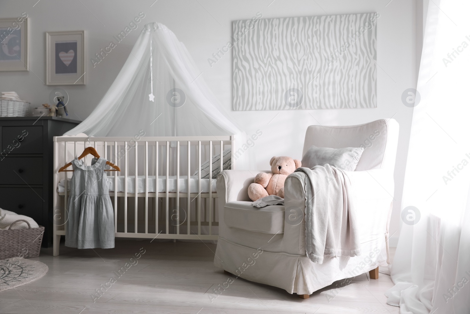 Photo of Baby room interior with comfortable crib and armchair