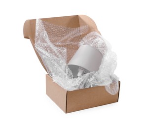 Photo of Lamp with bubble wrap in cardboard box isolated on white